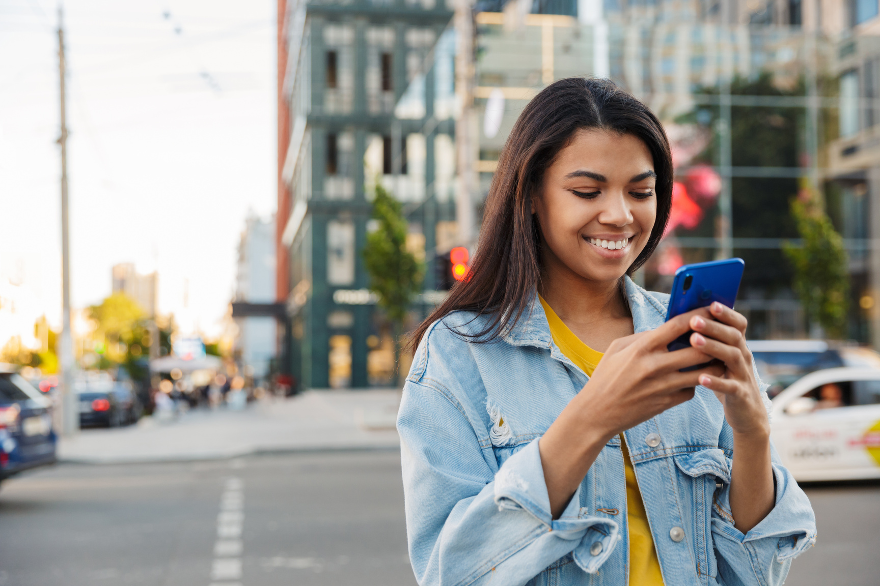 Young Smiling Casual African Woman Using Mobile Phone